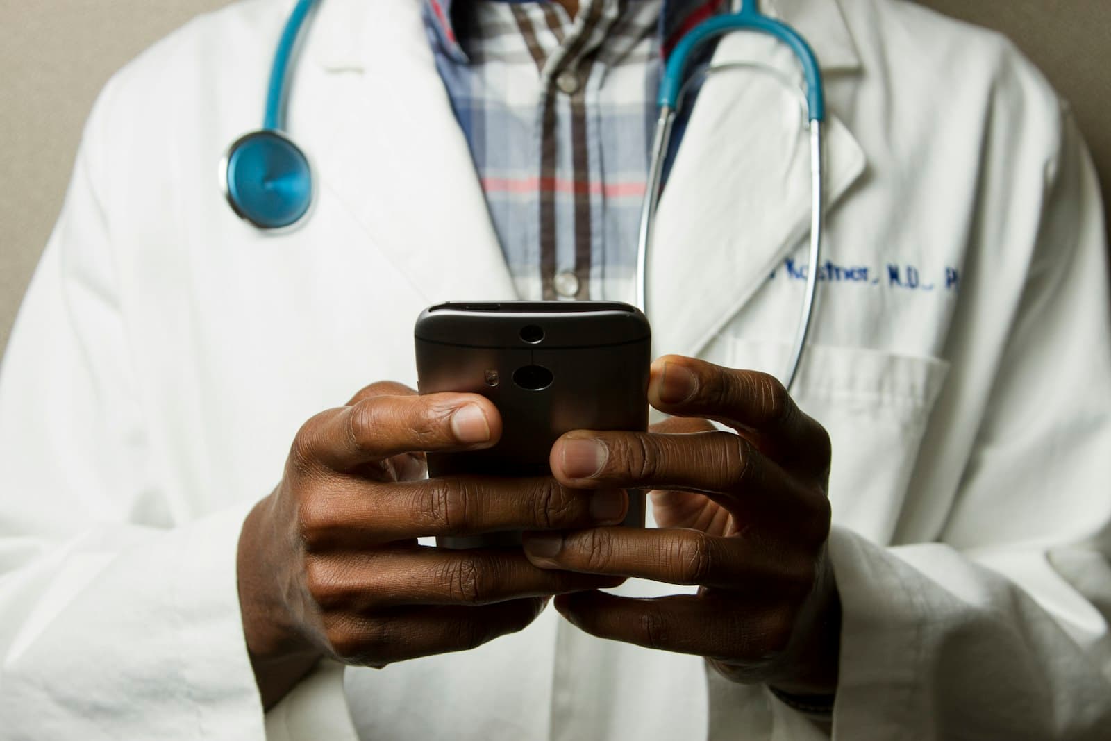 A physician sending a message from their phone